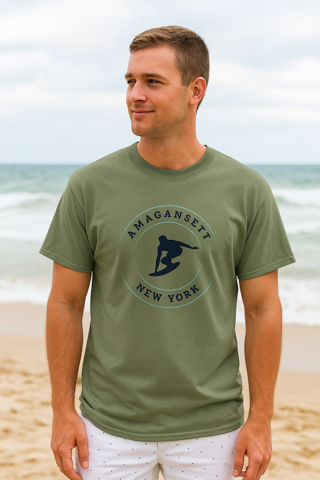 Amagansett Surfing T-Shirt – Retro Surf Tee in olive green worn by man on beach, featuring vintage surfer graphic and coastal New York text.