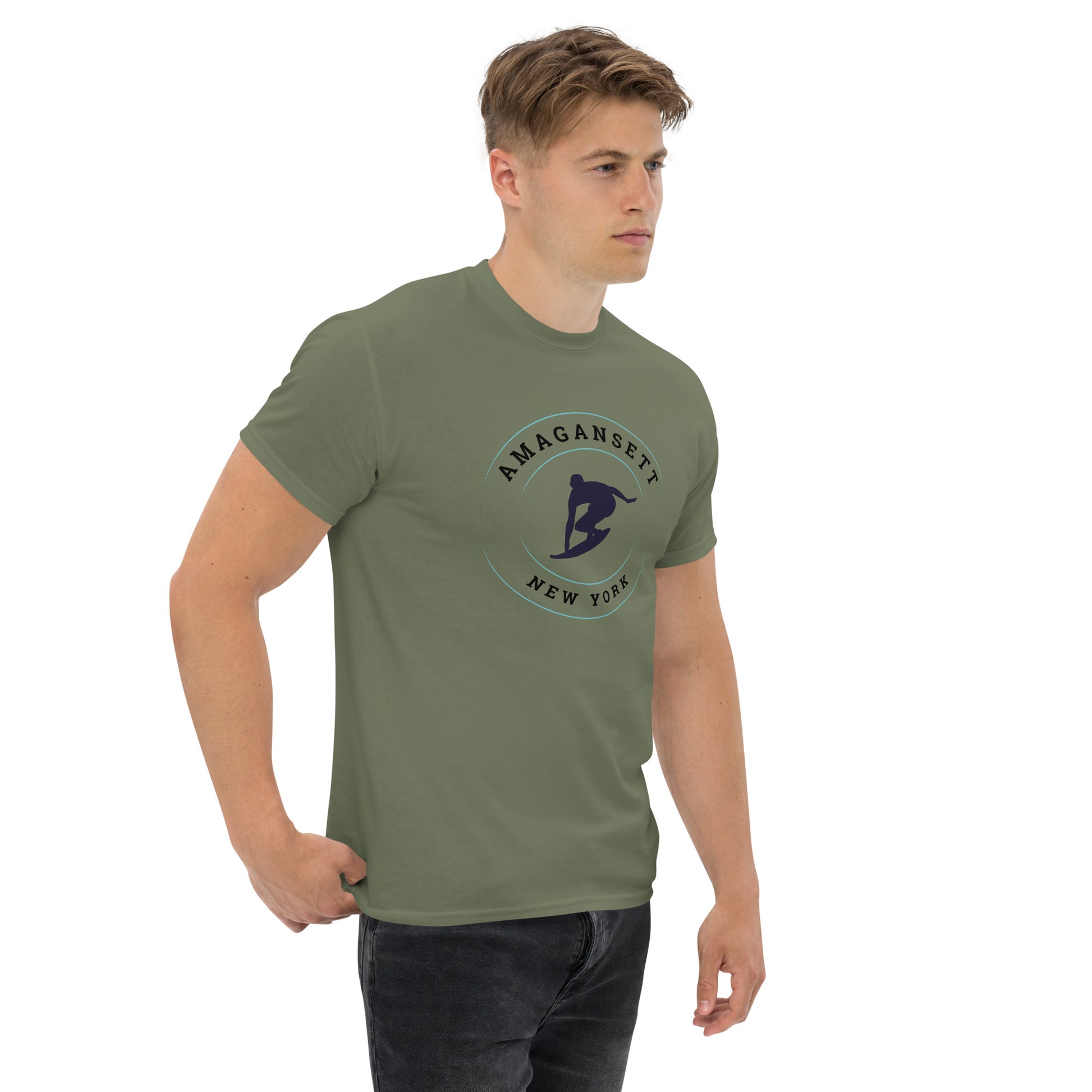 Amagansett Surfing T-Shirt – Retro Surf Tee in olive green modeled indoors, showcasing bold surfer silhouette and East Coast beach town vibe.