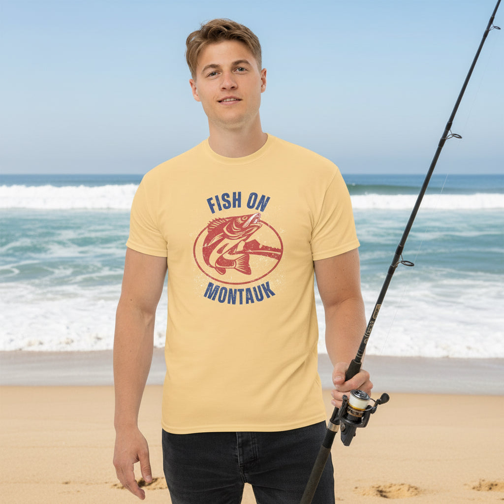 Montauk Fishing T-Shirt in soft yellow worn by male model, featuring vintage red striped bass graphic and 'Fish On Montauk' text.