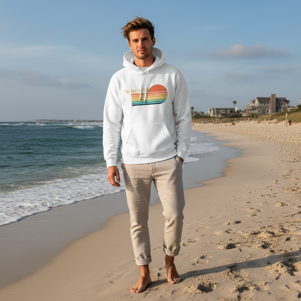 Man wearing a white hoodie with a colorful design on a beach